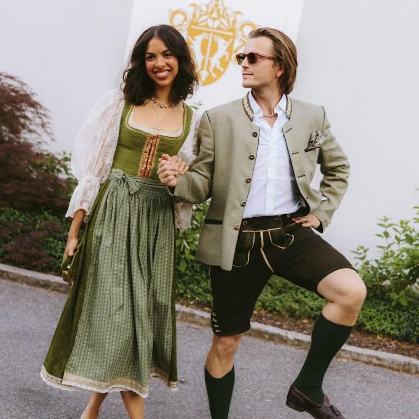 Mann in Lederhose und Frau in Dirndl, Händchen haltend