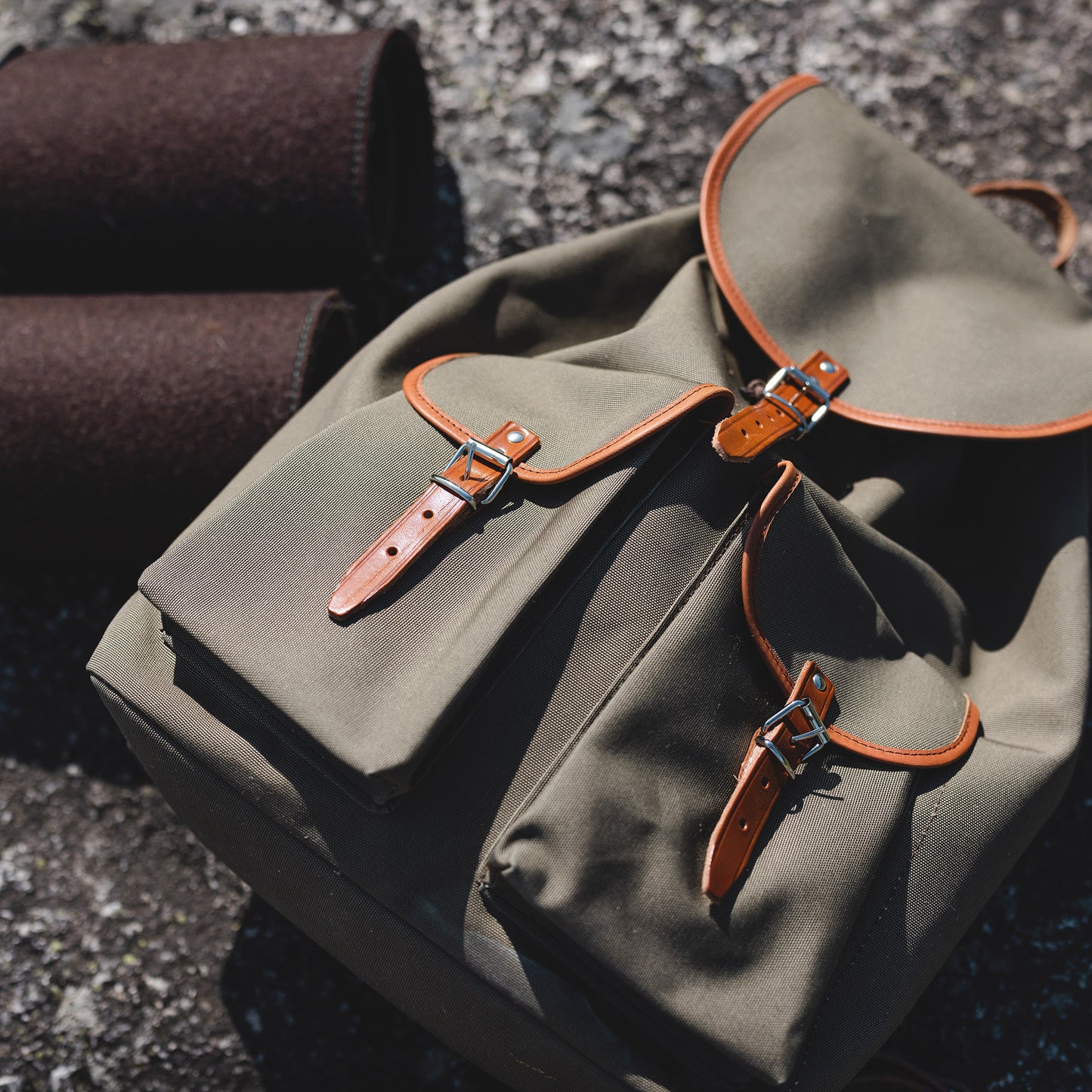 Grüner Rucksack auf Steinboden