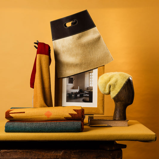 Mütze, Schal, Tasche und Decken neben Bild auf gelbem Hintergrund