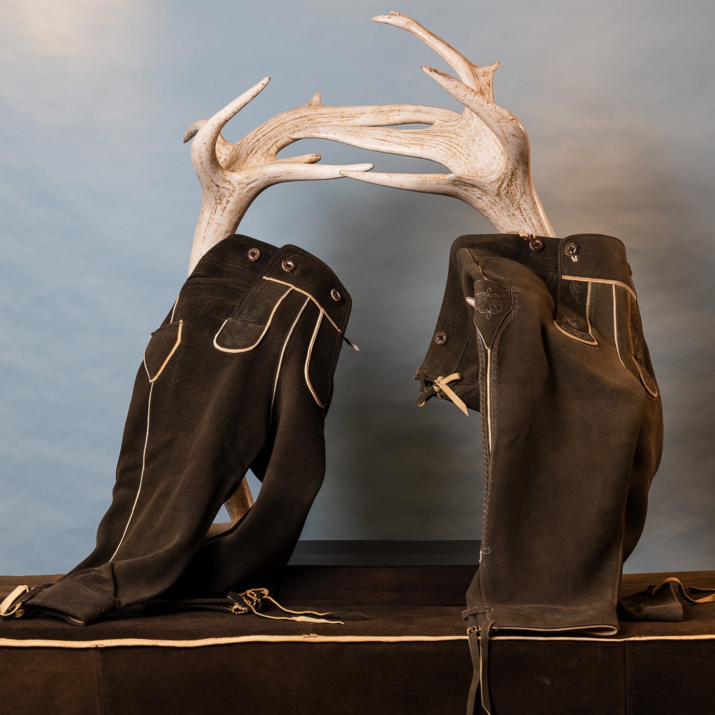 Zwei Lederhosen auf einem Hirschgeweih